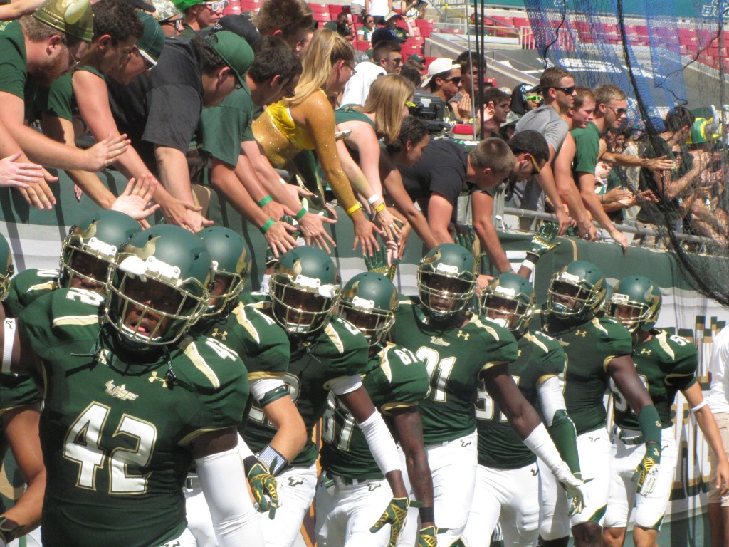 The Bulls line up for high-fives with fans before playing against the N.C. State Wolfpack. The game ended in a 49-17 loss after lackluster momentum.