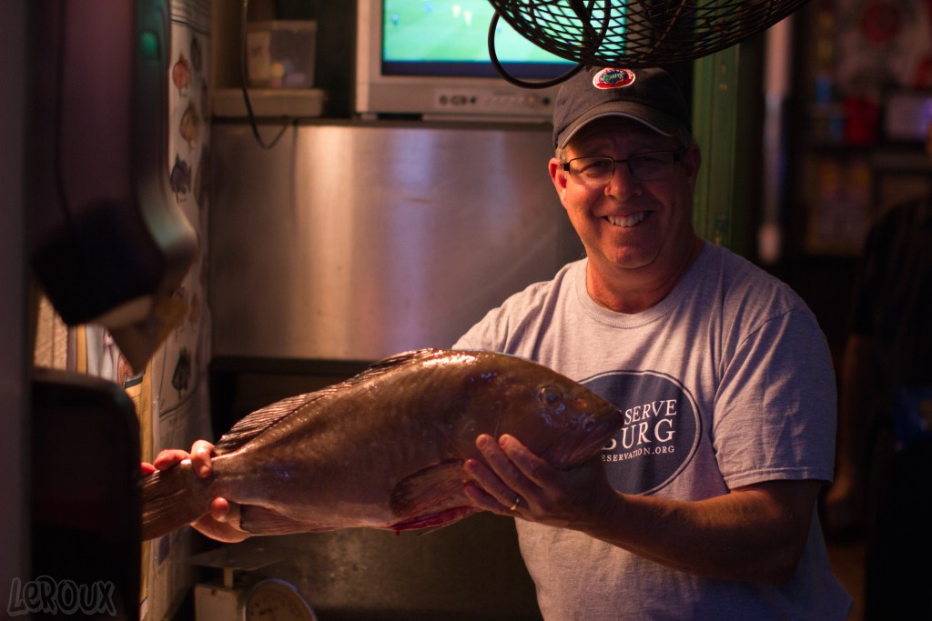 Tavern owner Tom Herzhauser holds up a grouper he filleted.  The Tavern, unlike many restaurants fillets fish on site. The grouper sandwiches at the Tavern are one of the their most popular items. 